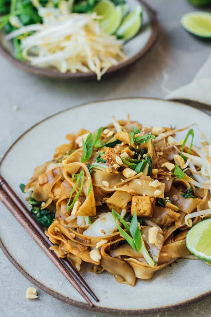 a plate of pad see ew with chopsticks on the side