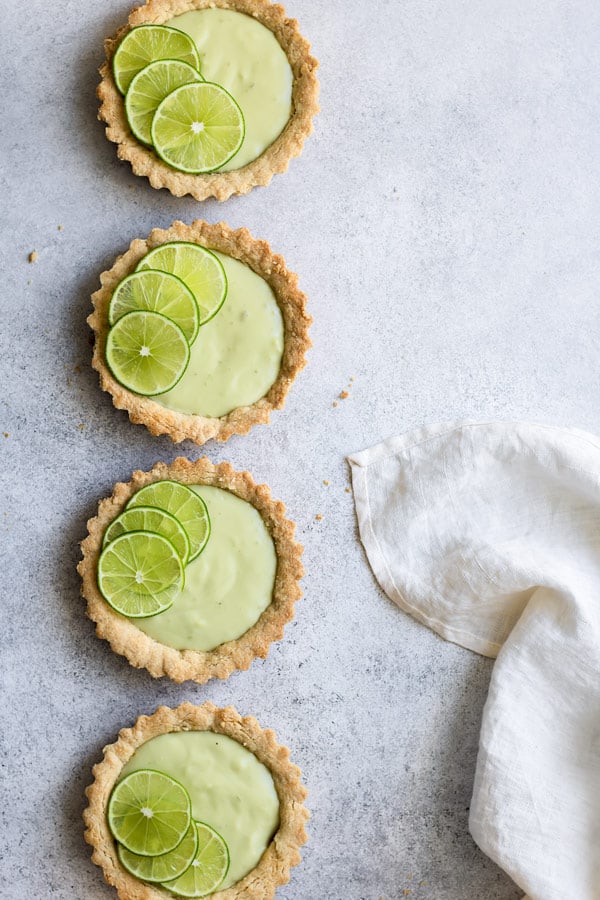 a row of 4 mini vegan key lime pies
