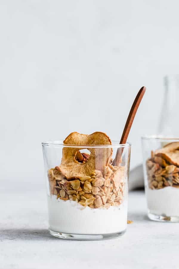 A cup with yogurt and apple granola in it