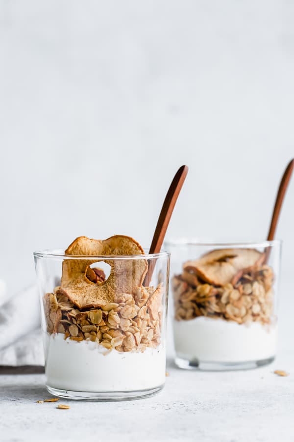 Two cups with yogurt and apple pie granola in them