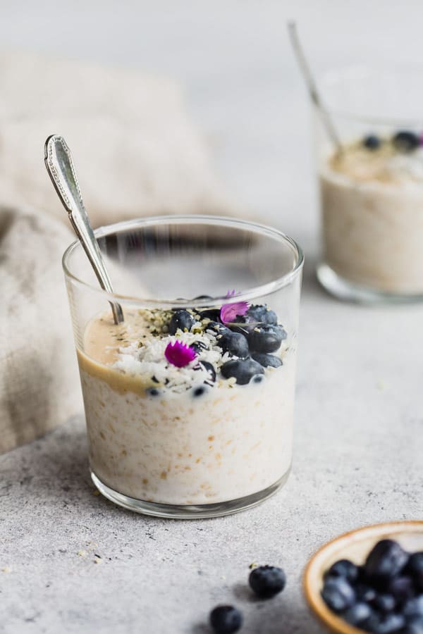 overnight steel cut oats in a cup with blueberries around it