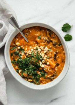 a bowl of West African peanut stew with a grey napkin on the side