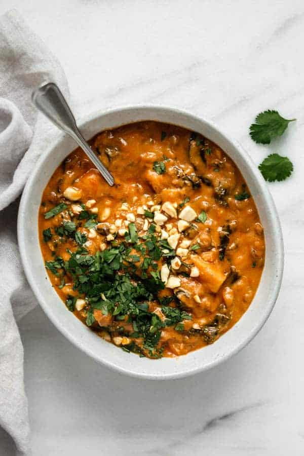 a bowl of West African peanut stew with a grey napkin on the side