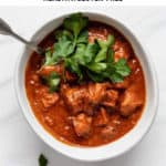a bowl of tofu tikka masala topped with herbs