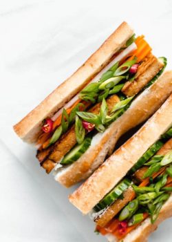 a plate with a tofu banh mi sandwich filled with pickled vegetables