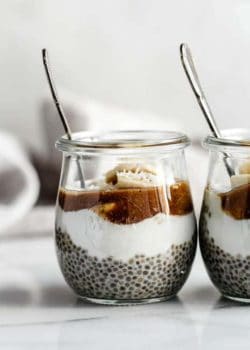 small jars filled with chia pudding, bananas, yogurt and caramel sauce