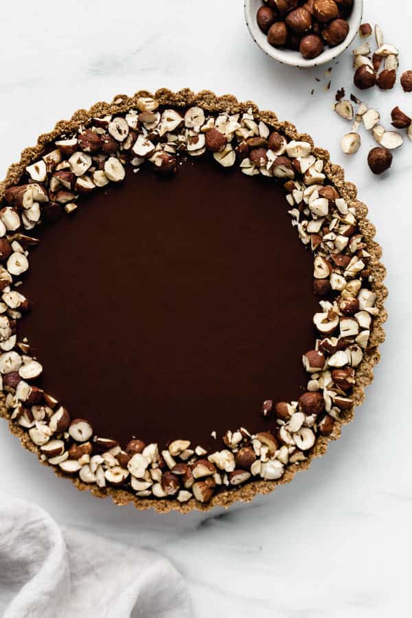 a chocolate hazelnut tart topped with crushed hazelnuts