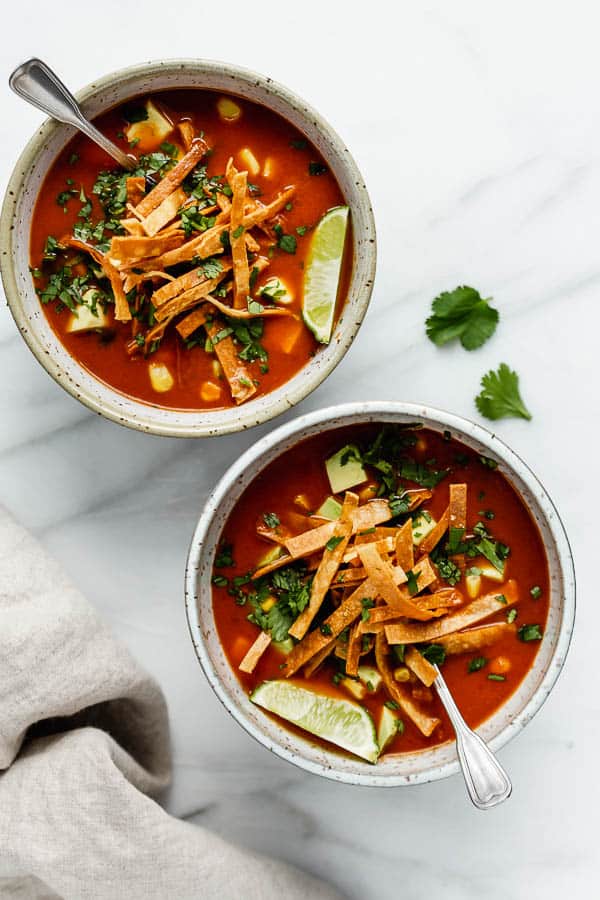 a tortilla soup topped with tortilla strips and fresh cilantro