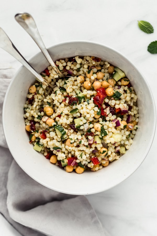 A large bowl of Israeli couscous salad
