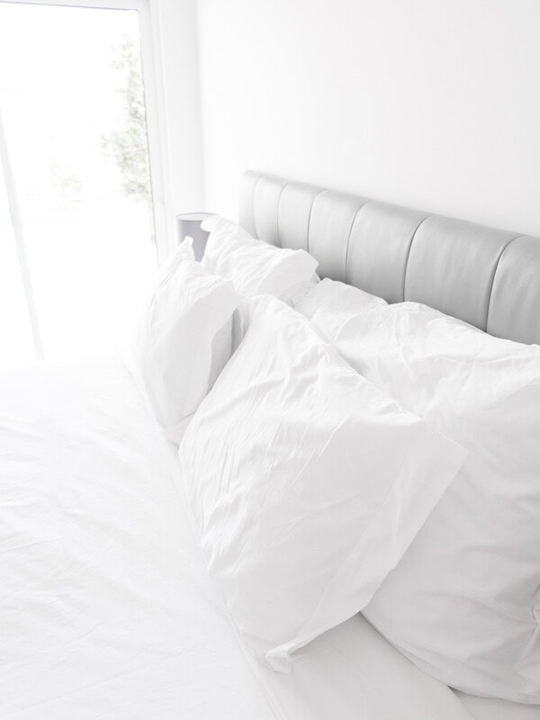 A white bed with white pillows