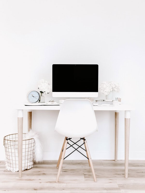 a desk with an imac and a chair