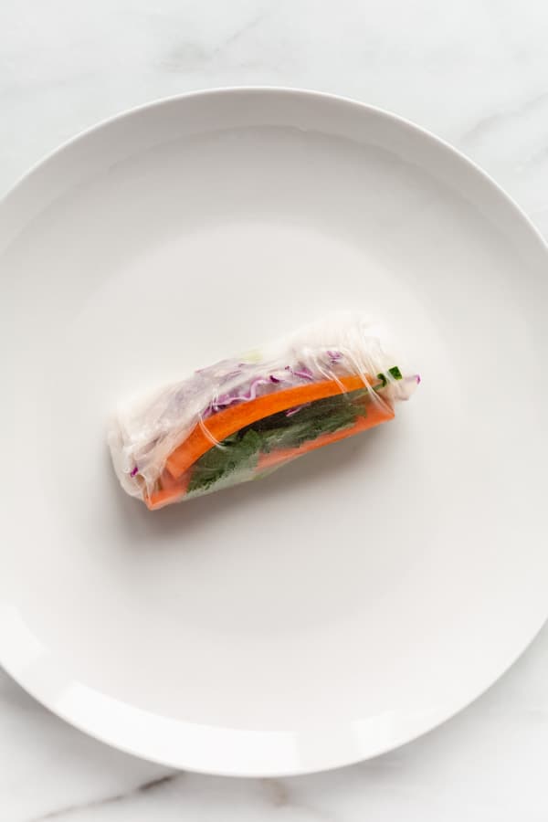 a fresh spring roll on a white plate