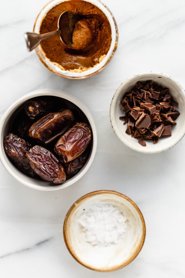 dates, almond butter, chocolate and sea salt on a marble board
