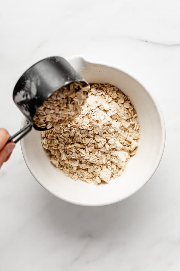 pouring oats into a mixing bowl