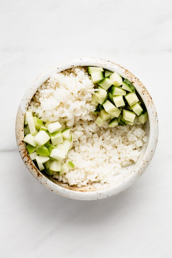 bowl with rice cucumber and cut up green apple