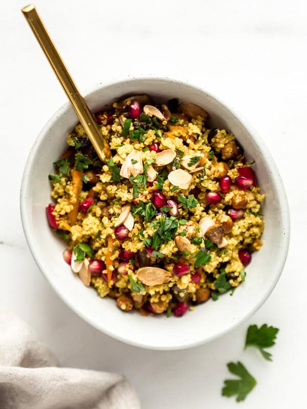 A bowl with Moroccan quinoa salad and a gold spoon