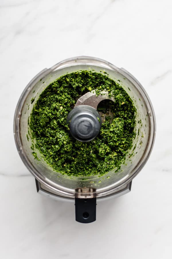 a food processor with kale pesto in it