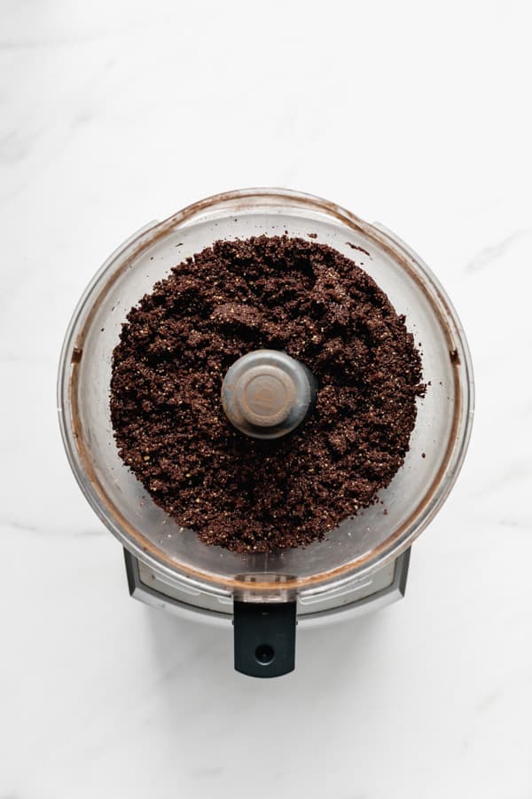 a food processor with blended raw brownie mix