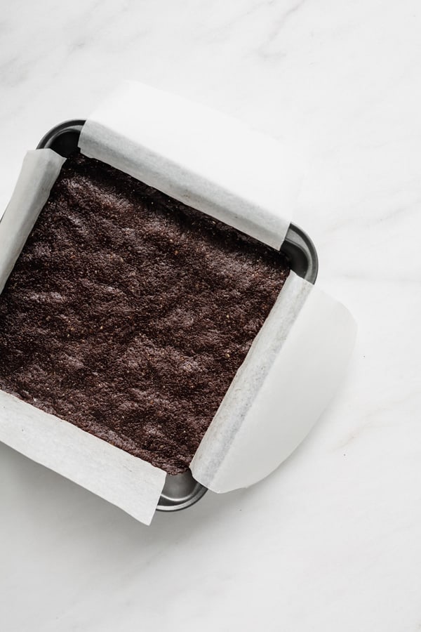an 8x8 inch pan with raw brownies in it