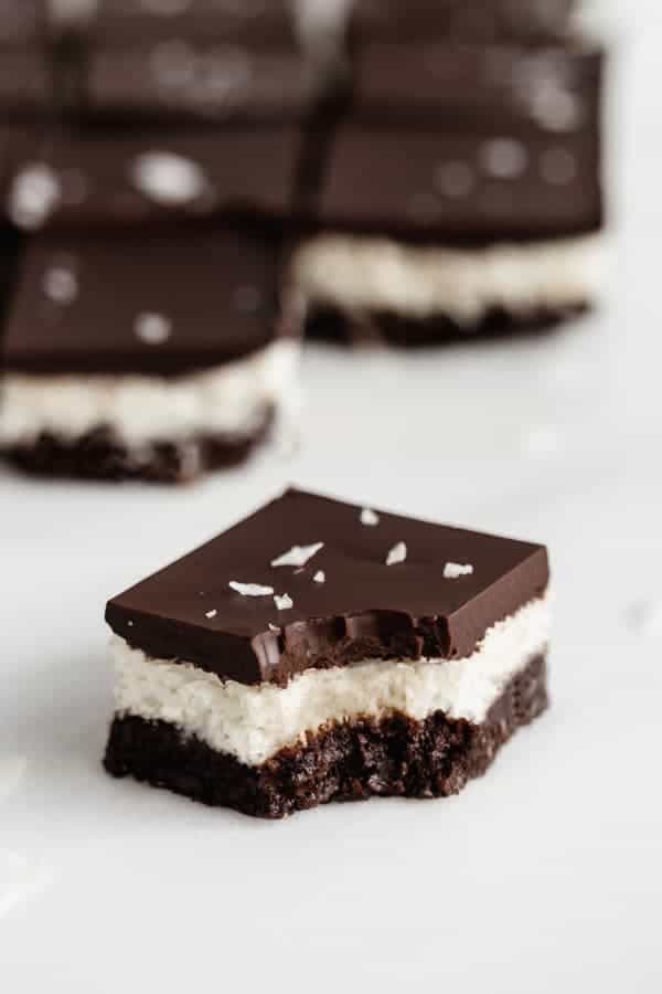 a no bake coconut brownie with a bite taken out of it
