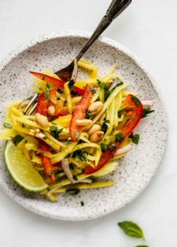 a white plat with mango salad on it