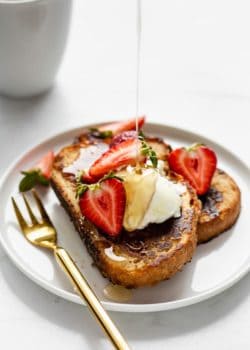 a plate of vegan french toast with maple syrup being poured on it