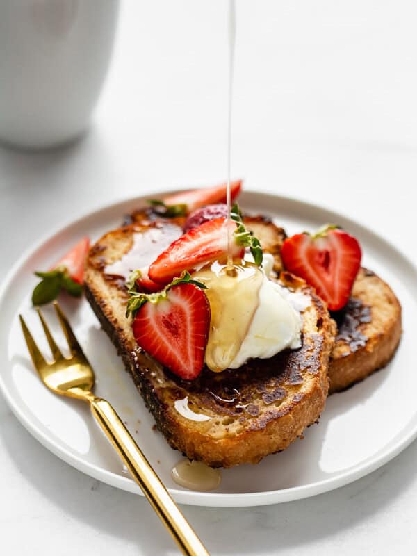 a plate of vegan french toast with maple syrup being poured on it