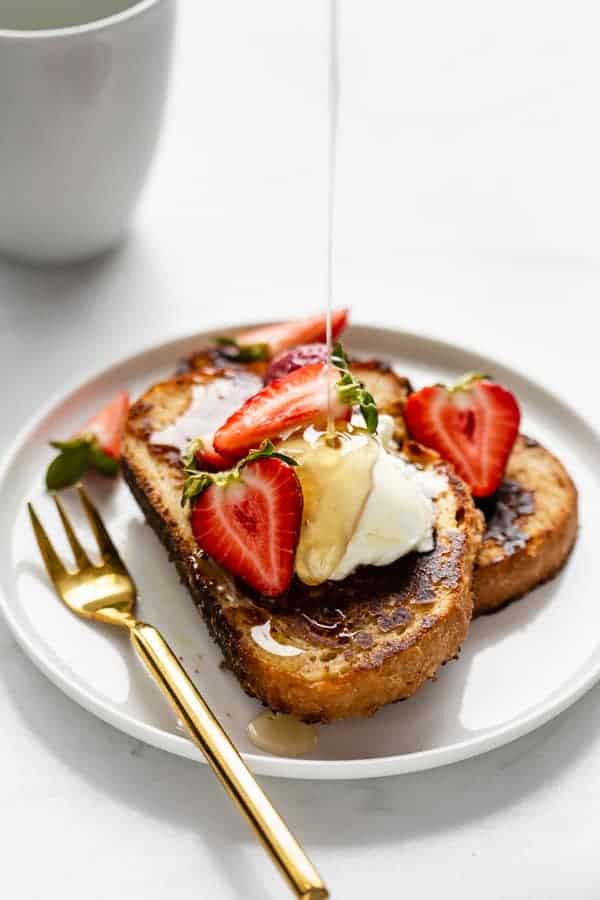 a plate of vegan french toast with maple syrup being poured on it