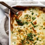 a baking dish with lentil moussaka topped with chopped parsley