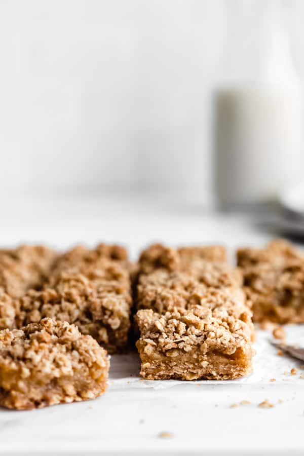 Apple pie bars cut up into squares on a white marble countertop