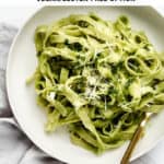 a plate of avocado pasta with a gold fork in it