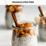 a jar of chia pudding topped with cooked apples and a cinnamon stick in it