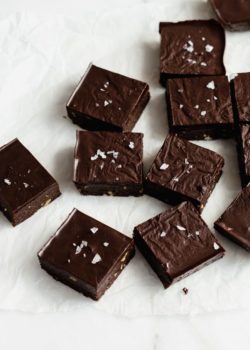 raw chocolate brownies cut up in squares on parchment paper