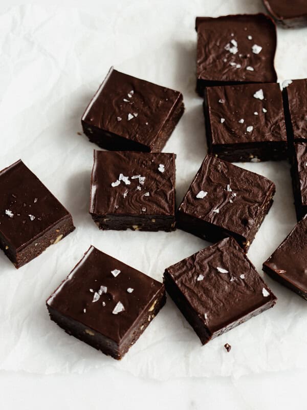 raw chocolate brownies cut up in squares on parchment paper