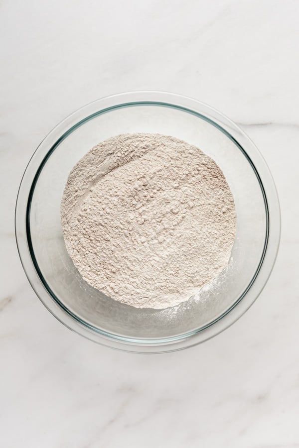 a clear mixing bowl with flour in it