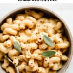 a bowl of mac and cheese topped with sage leaves