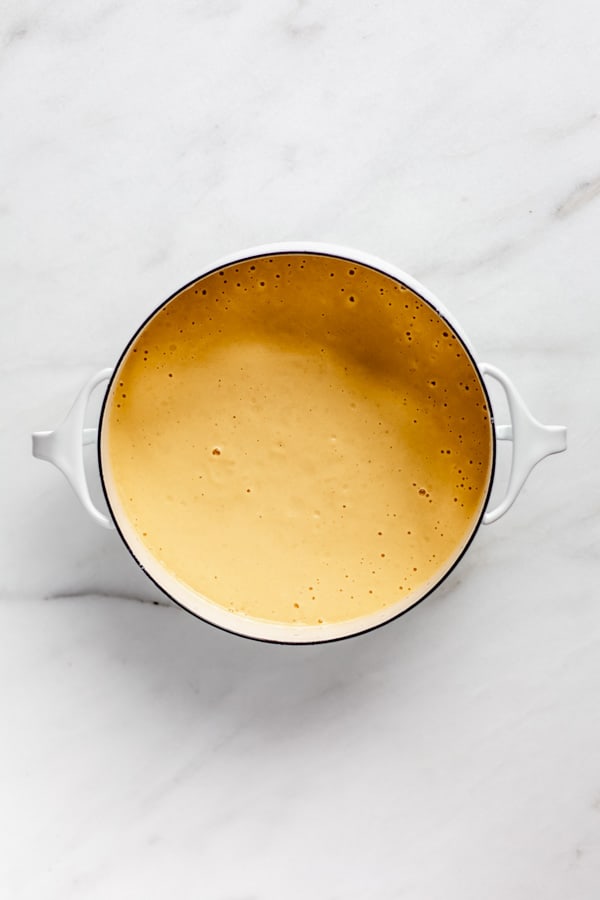 a white pot filled with vegan butternut squash cheese sauce