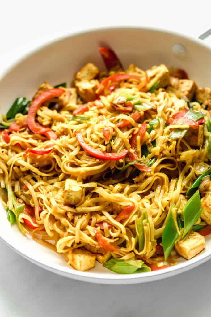 singapore noodles in a pan with peppers and tofu