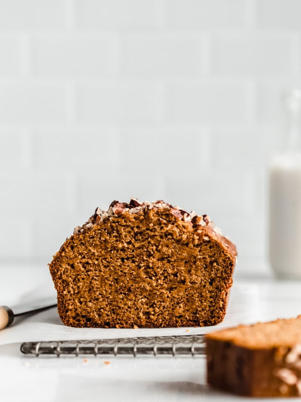 pumpkin bread with a slice missing on a cooling rack