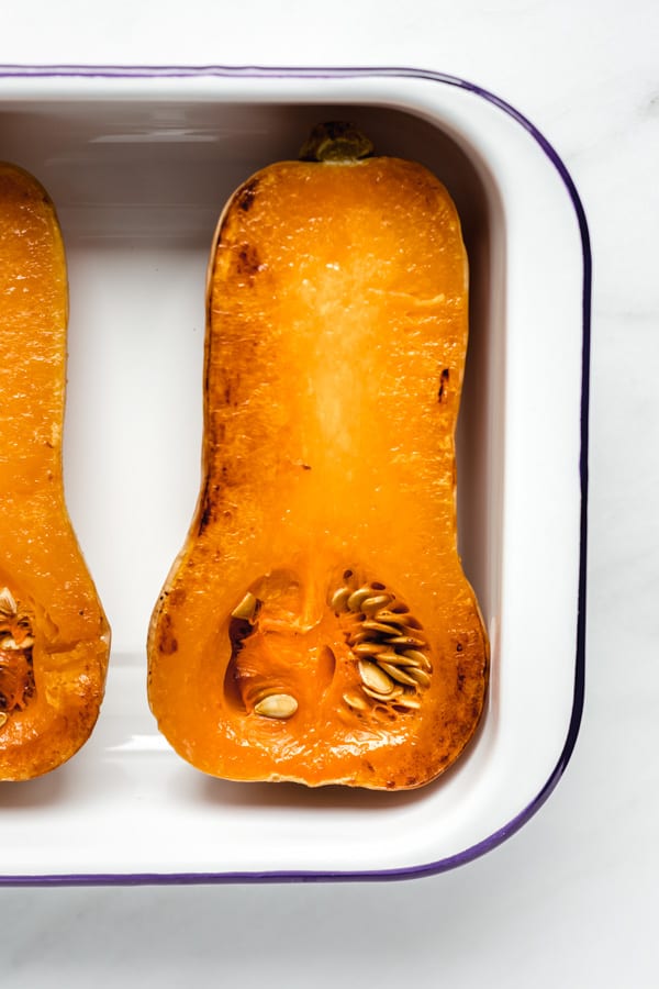 a roasted butternut squash in a white pan