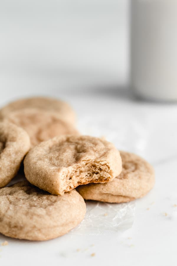 a pile of snickerdoodle cookies on a piece of parchment paper