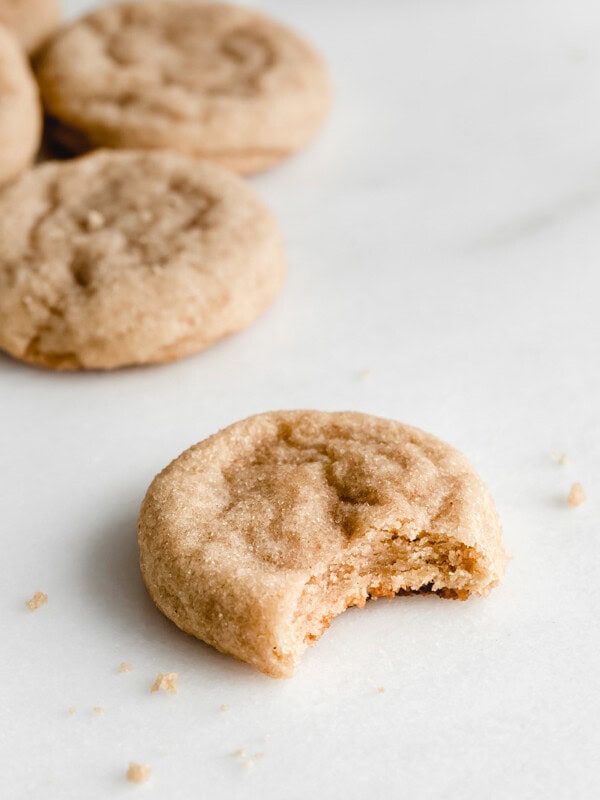 a snickerdoodle cookie on a marble board with a bite taken out of it
