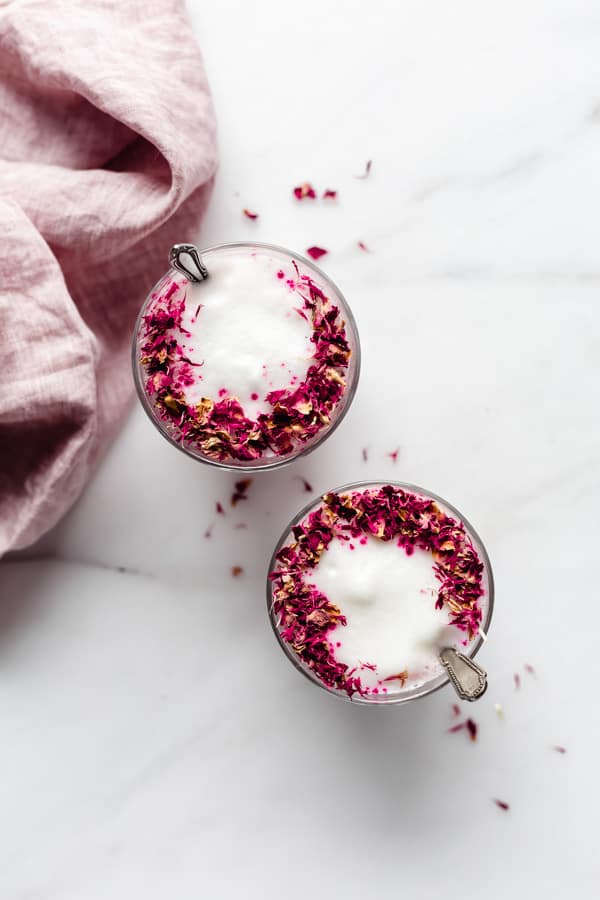 two glasses of hibiscus rose lattes topped with rose petals