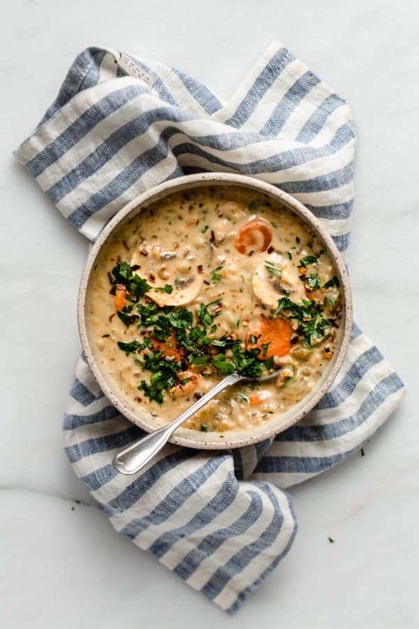 wild rice soup in a bowl on top of a blue striped napkin