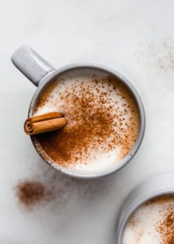 a blue cup filled with a pumpkin latte in it topped with cinnamon