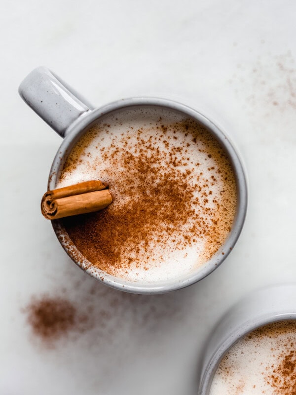 a blue cup filled with a pumpkin latte in it topped with cinnamon