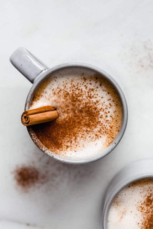 a blue cup filled with a pumpkin latte in it topped with cinnamon