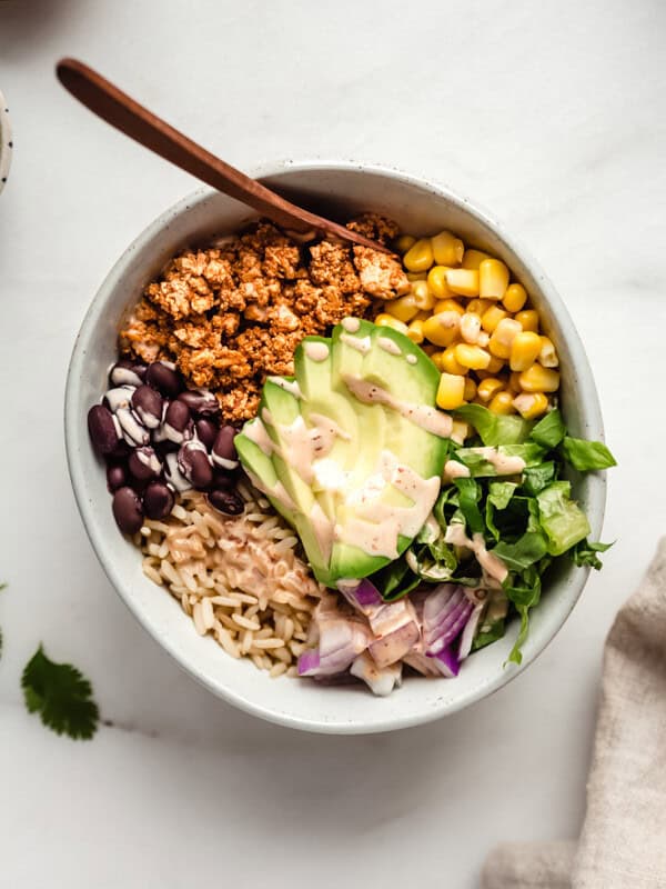 A bowl of chipotle sofrtias with avocado, rice, beans, corn and lettuce