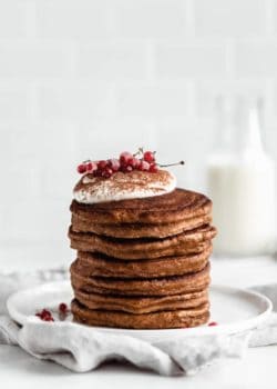 a stack of gingerbread pancakes topped with yogurt and currants