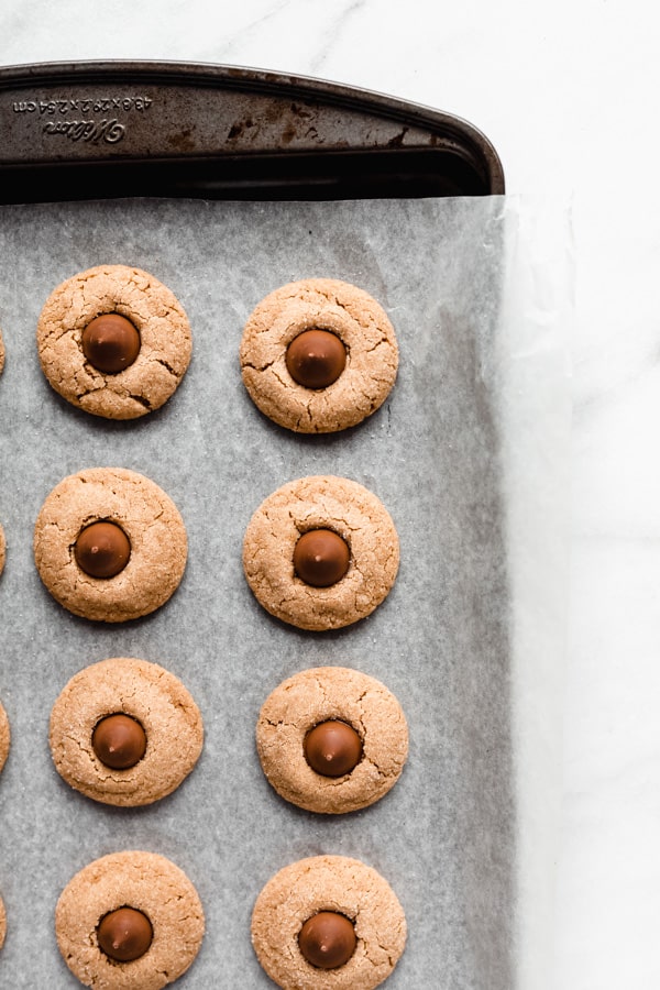 baked peanut butter blossom cooking on a baking sheet